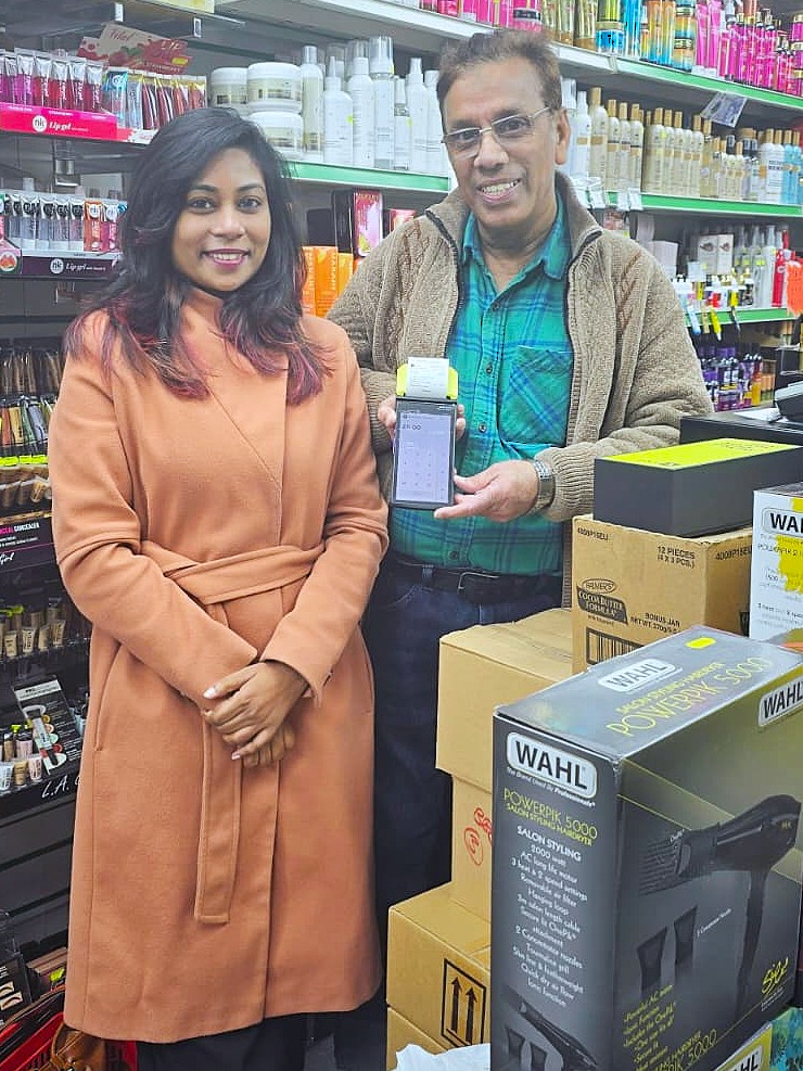 Happy with the owner of a beauty and hair supplies shop, new terminal in hand